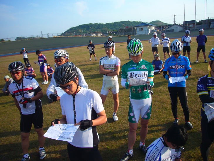 自転車競技場の中でブリーフィングに聞き入る