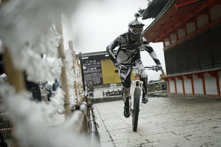 願いを込めたおみくじの脇を駆け抜けるライダーたち