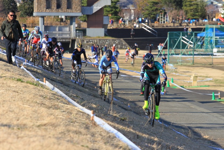 土手のキャンバーを行く選手たち。藤田拓海（SNELCYCLOCROSSTEAM）がトップを猛追する