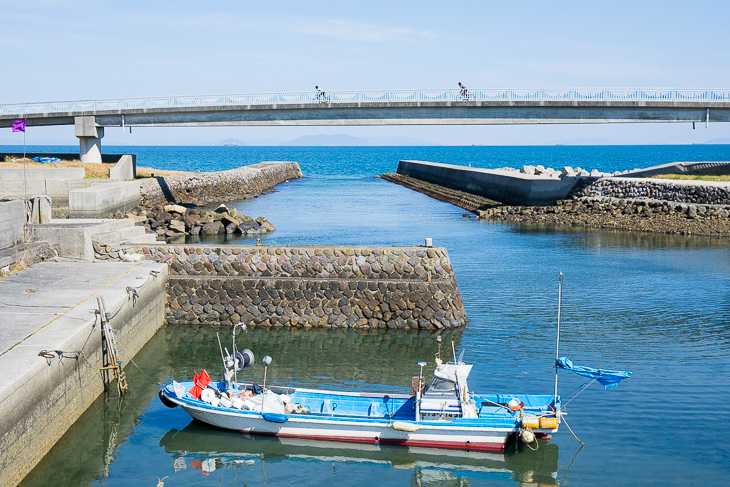 小さな漁港をサイクリングロードがまたぐ。海の青さが南にいることを教えてくれた