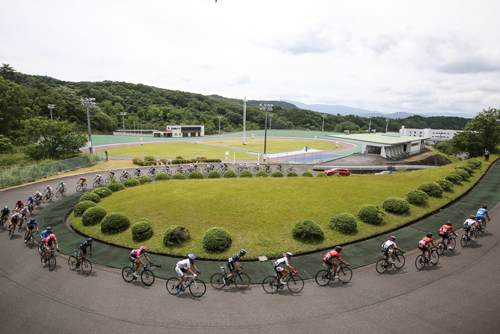 日本競輪学校のトラックを横目に走るメイン集団