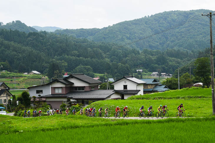 山間部の集落の中を行く集団