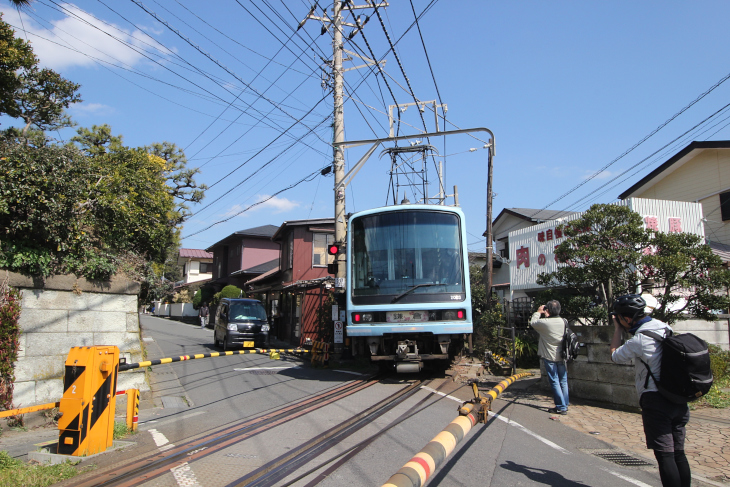 江ノ島電鉄は住宅が立ち並ぶなかを走るため迫力満点だ