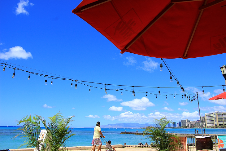 赤いパラソルと青い海のコントラストが美しいベアフットビーチカフェ