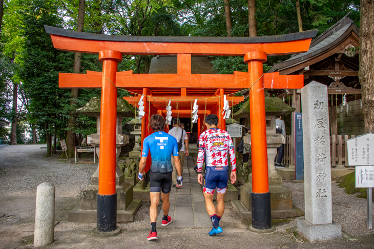 境内の中にある初辰稲荷神社の鳥居をくぐる鈴木さんと小坂選手