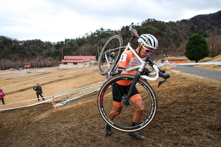 男子マスターズ40-44　バイクを担いでキャンバーをクリアする筧五郎（56サイクル）