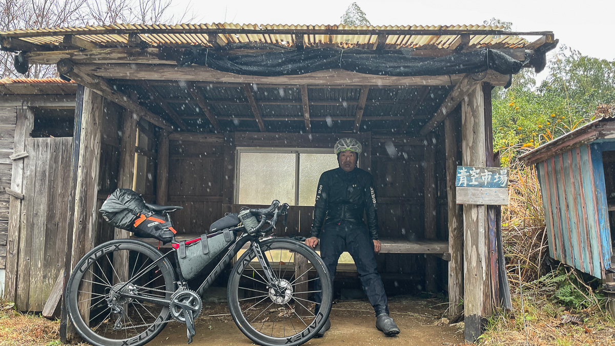 屋根を見つけて雨宿り。「青空市場」とあるのは皮肉かな？ 