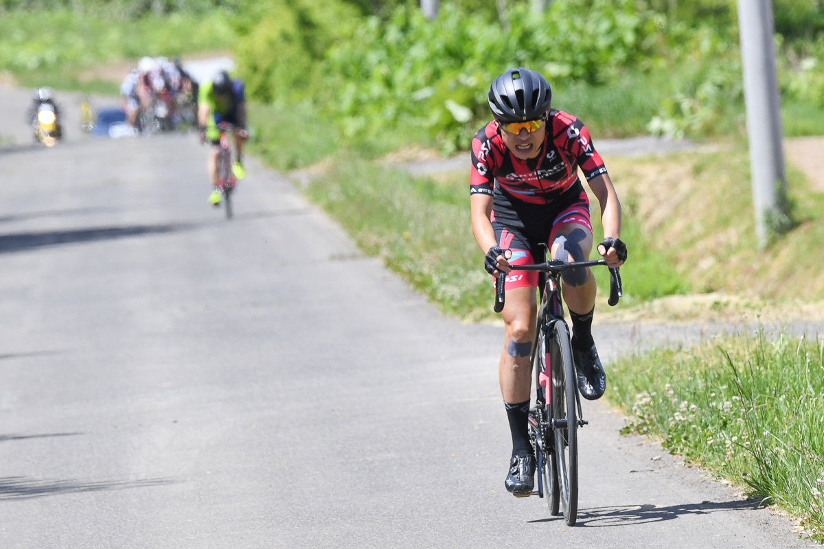 6月のニセコクラシック2022、残り10kmを切り独走して優勝した石井祥平（アーティファクトレーシングチーム）85km参加者の後方に追走集団が迫る