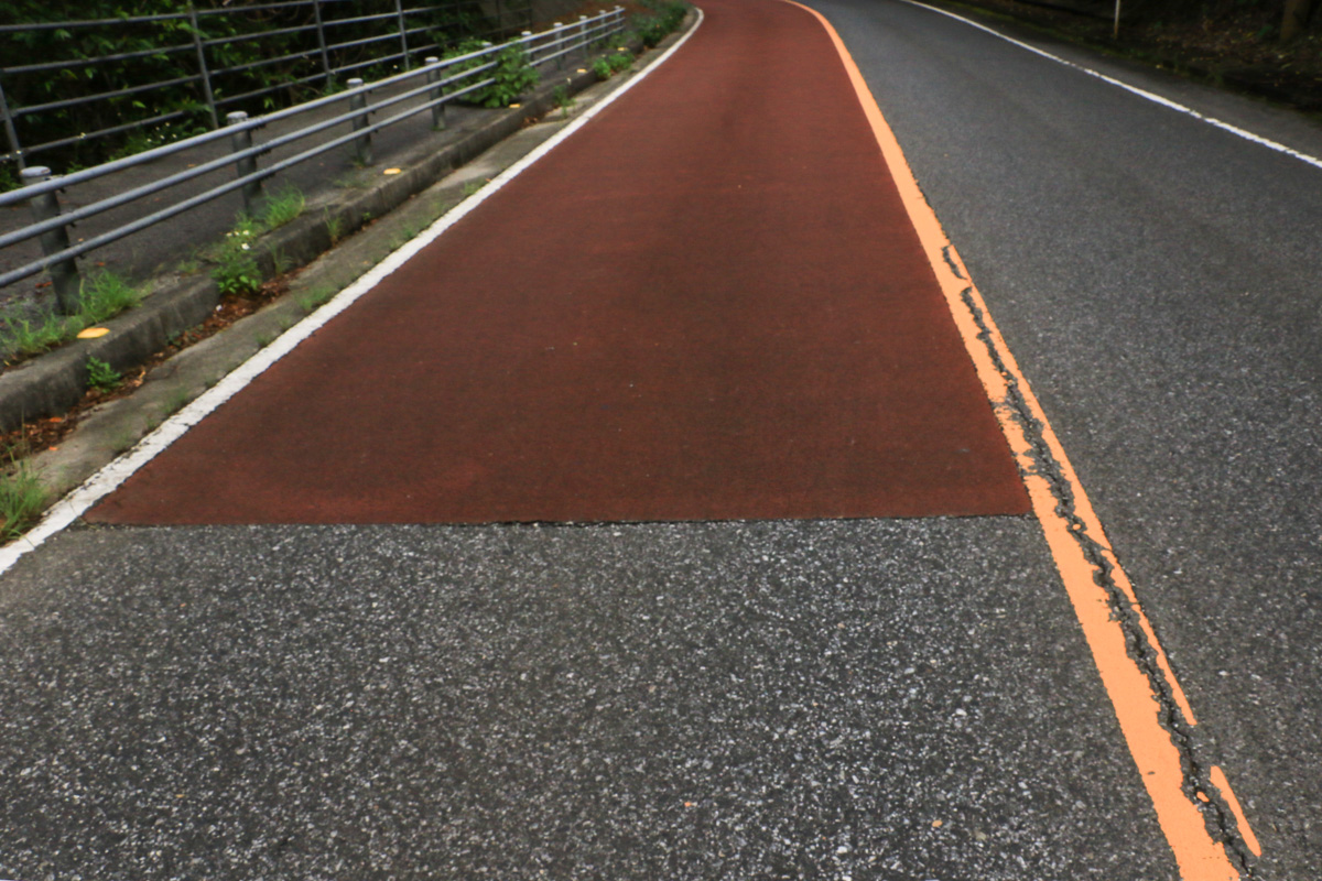 下りの左車線が滑り止め加工がされた赤い路面となる