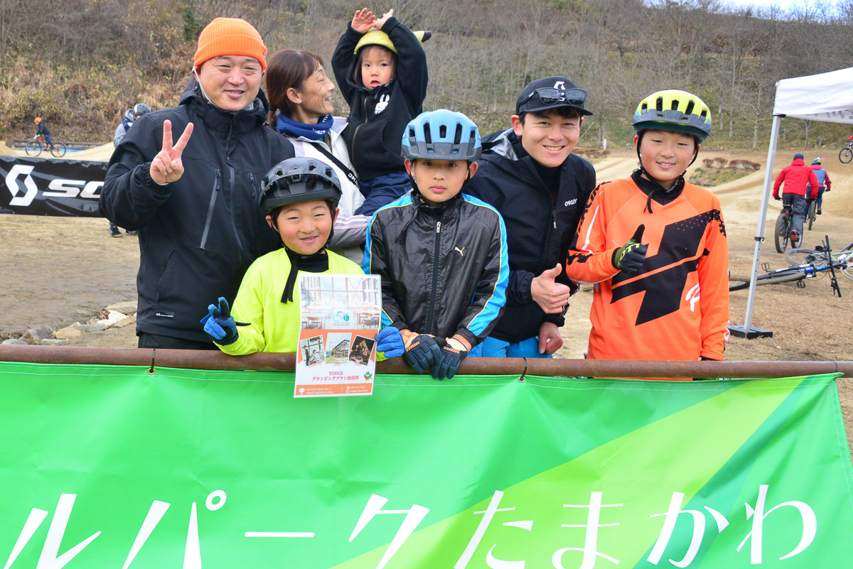 この大会で特別賞をもらった村上耀太くん（前左から2番目）7歳とそのファミリー＋平林安里。耀太くんは、前回のレースでは上りが登れなかっていたのに、今度はうまくなってジャンプまで飛んじゃってすごい！という理由での特別賞受賞。それがここのスピリット！